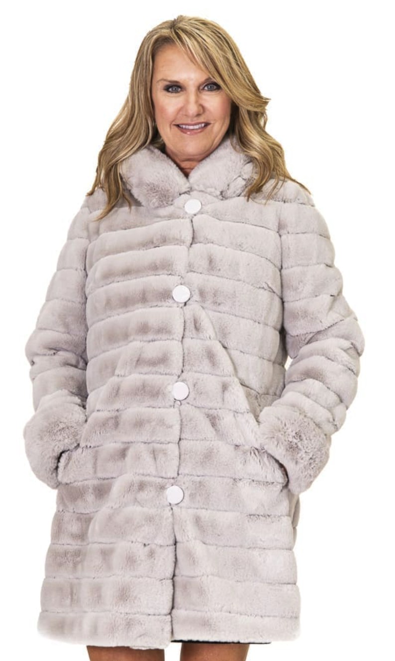 Woman wearing a pearl grey ribbed faux fur coat with round button closures and stand collar